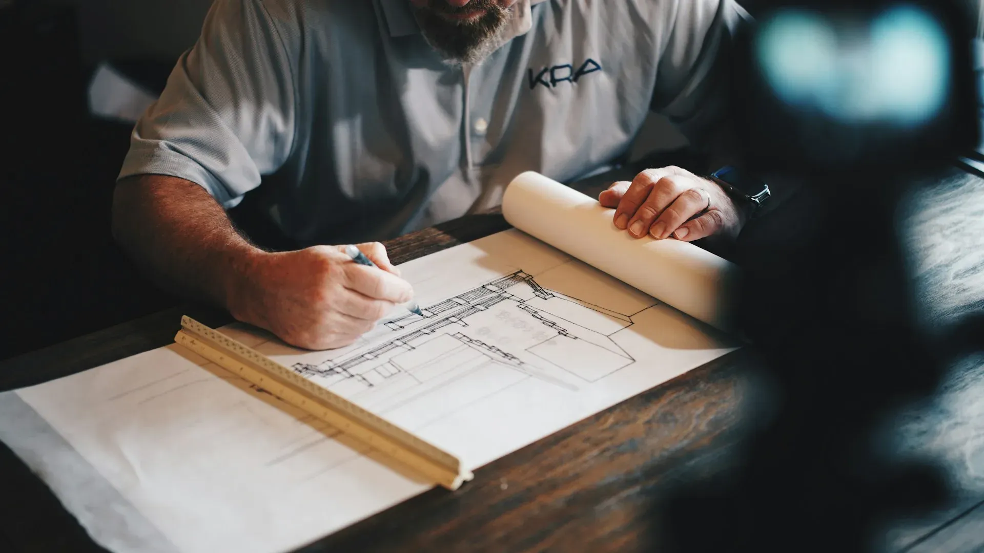 Architect reviewing building plans at a drawing desk