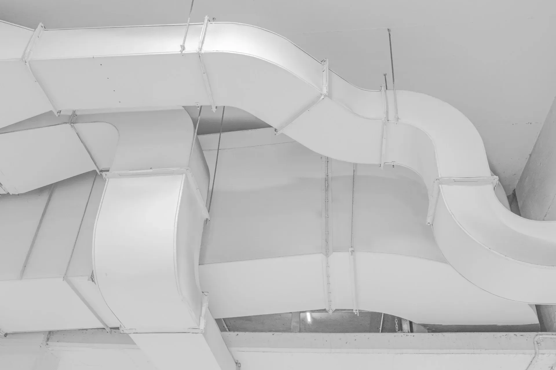 White ventilation ducts routed beneath an interior ceiling